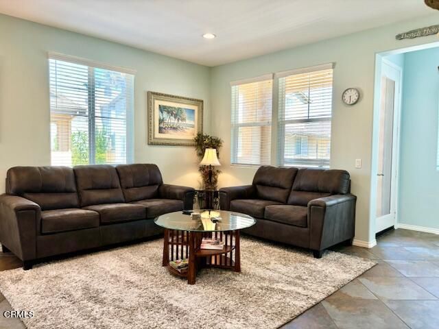a living room with furniture a window and a flat screen tv