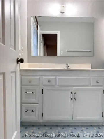 a bathroom with a sink vanity and mirror