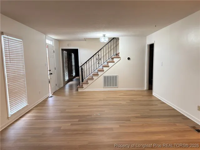 a view of entryway and hall with wooden floor