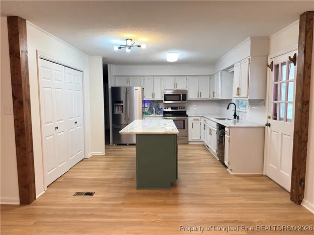 a large kitchen with cabinets and wooden floor