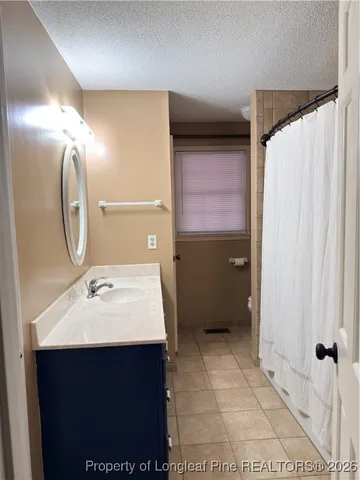 a bathroom with a sink mirror and shower