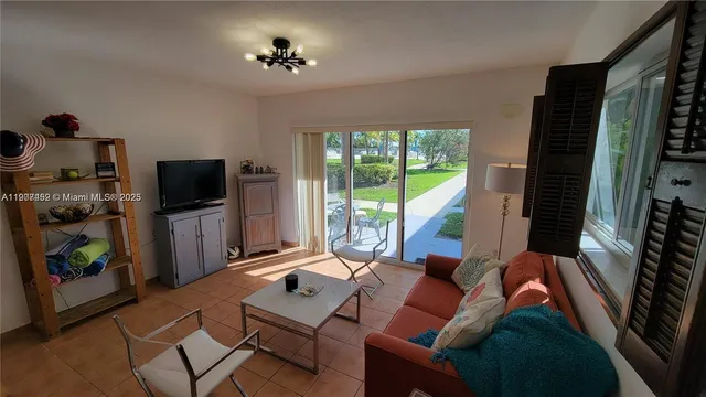 a living room with furniture a flat screen tv and a floor to ceiling window