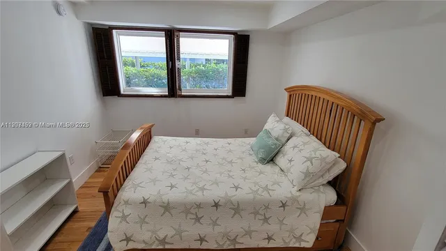 a bed sitting in a bedroom next to a window with lamp