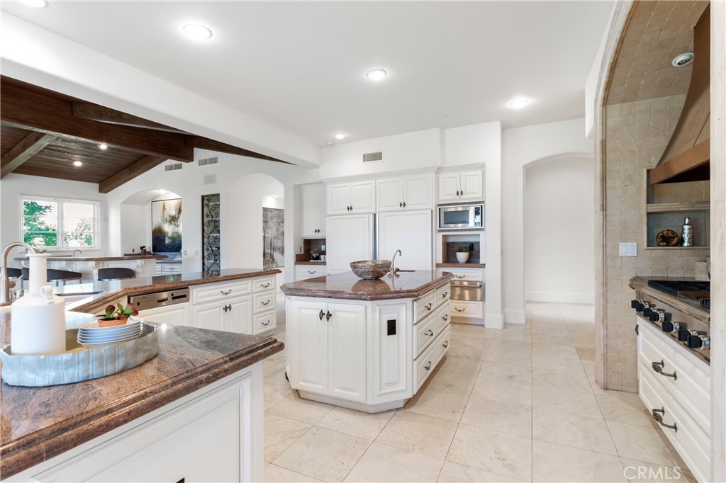 18090 Old Coach Drive Poway, CA 92064 - Photo 28 of 75 a large white kitchen with stainless steel appliances kitchen island granite countertop a large counter top and a stove
