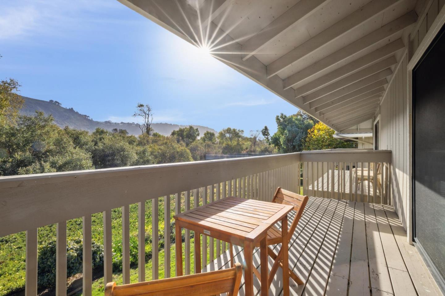 3850 Rio Road, Unit 1 Carmel, CA 93923 - Photo 27 of 46 a view of a balcony with wooden floor and outdoor seating
