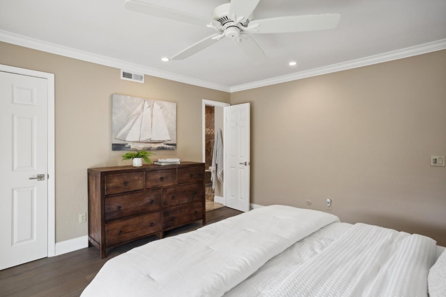 3850 Rio Road, Unit 1 Carmel, CA 93923 - Photo 30 of 46 a bedroom with a bed and ceiling fan