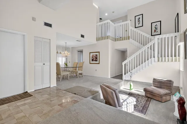 a view of a dining room that has a table and a chandelier