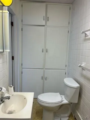 a white toilet sitting next to a bathroom sink