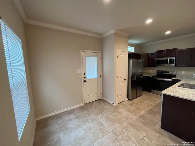 a view of a kitchen with a sink and a refrigerator