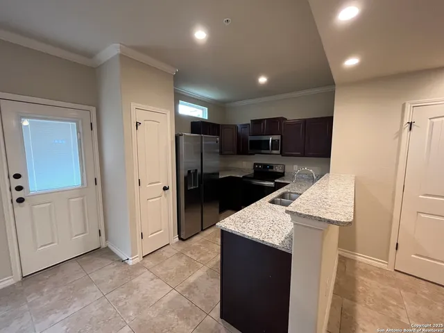 a kitchen with stainless steel appliances granite countertop a refrigerator and a sink