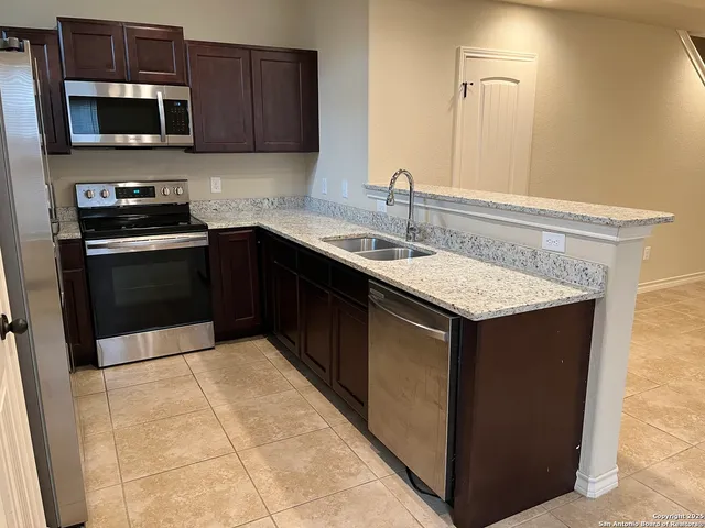 a kitchen with stainless steel appliances granite countertop a sink stove and microwave