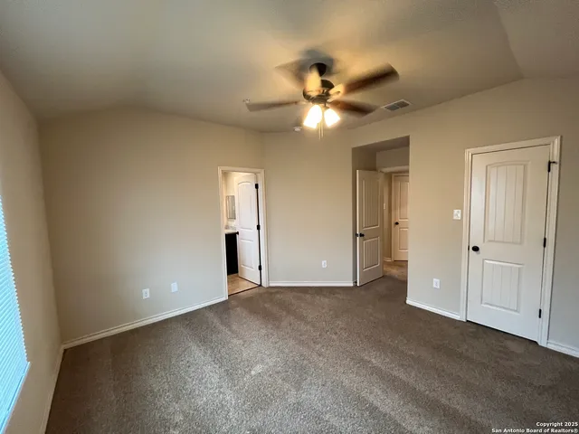 a view of an empty room and a ceiling fan