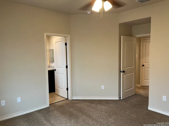an empty room with closet and a chandelier fan