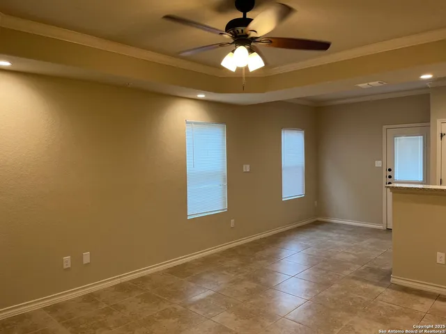 a view of an empty room with a chandelier fan