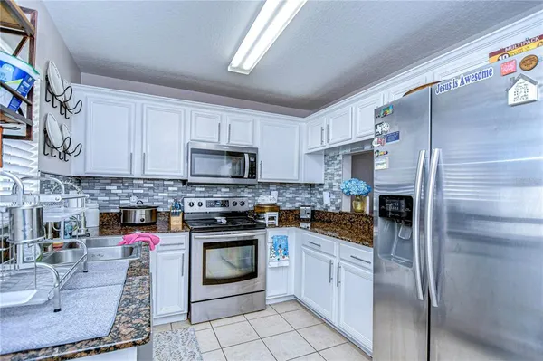 a kitchen with stainless steel appliances granite countertop a stove a sink and a refrigerator