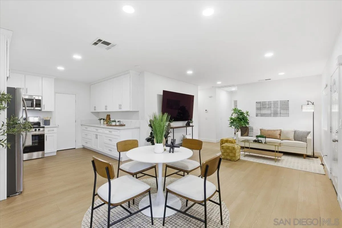 a kitchen with a dining table chairs and view living room