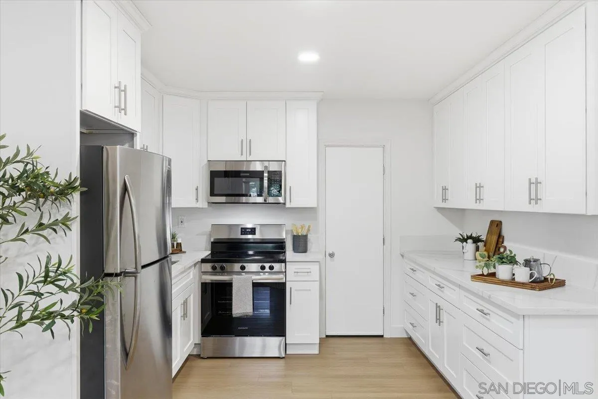 911 Jamacha Road El Cajon, CA 92019 - Photo 11 of 34 a kitchen with stainless steel appliances a refrigerator a stove and white cabinets