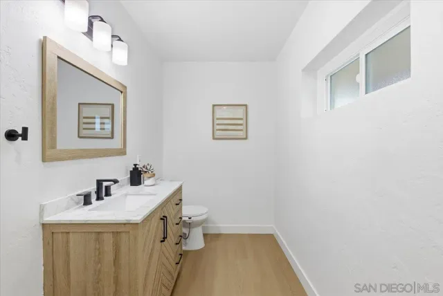 a bathroom with a sink a toilet and mirror