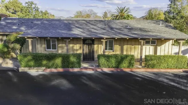 a front view of a house with a yard and potted plants
