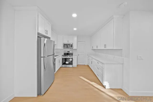 a kitchen with refrigerator and cabinets