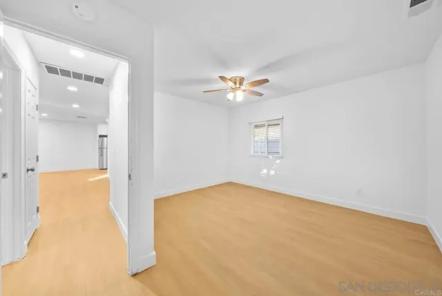 a view of an empty room with a chandelier fan