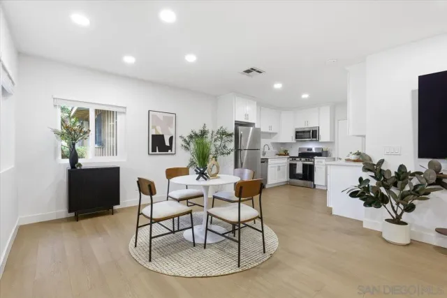 a living room with furniture and a dining table with kitchen view