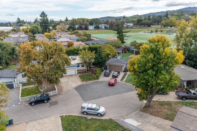 a view of a backyard with table and chairs plants and lake view