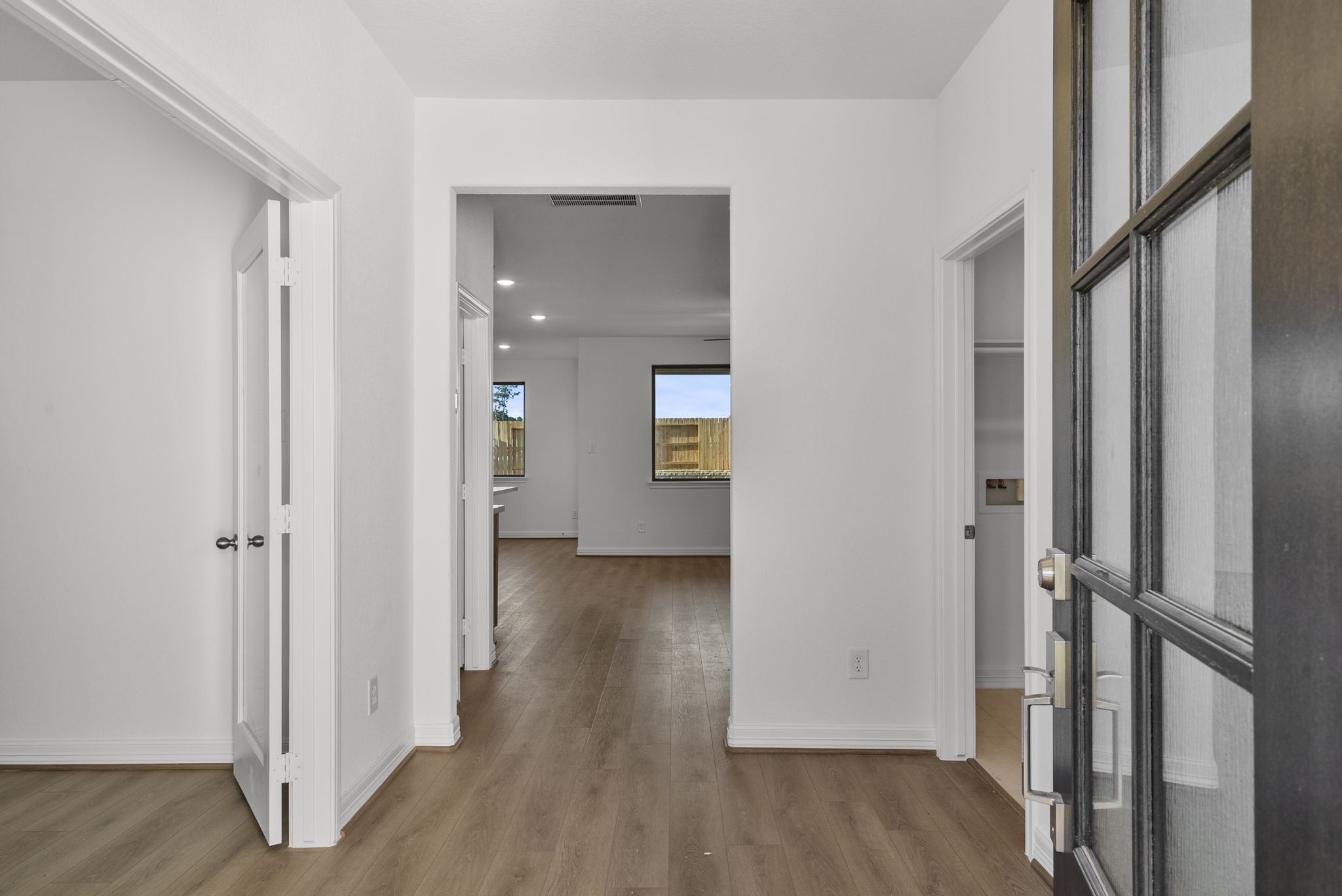 a view of a hallway with wooden floor and closet