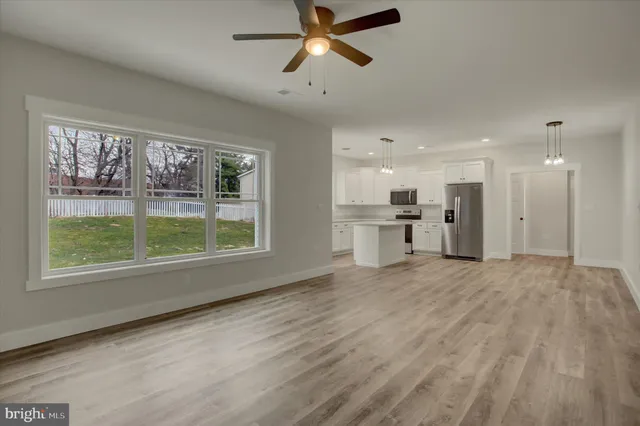 a view of empty room with wooden floor and window