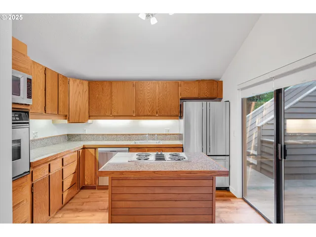 a kitchen with stainless steel appliances granite countertop a refrigerator and a sink