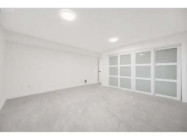 a view of an empty room with a kitchen