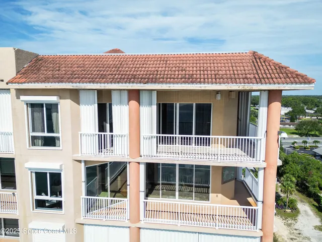 a view of a house with a large window and wooden fence