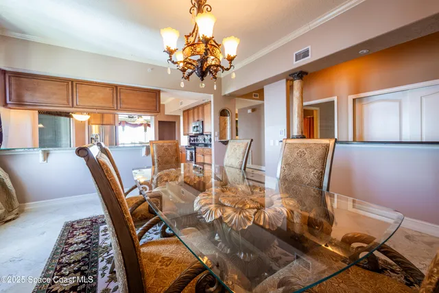 a view of a dining room with furniture a chandelier and wooden floor