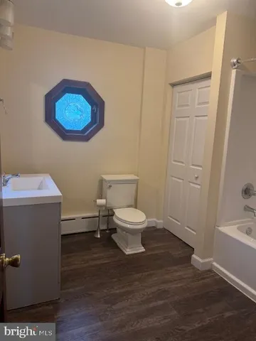 a bathroom with a toilet a sink and mirror