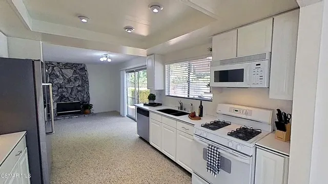 a kitchen with cabinets a sink and a refrigerator
