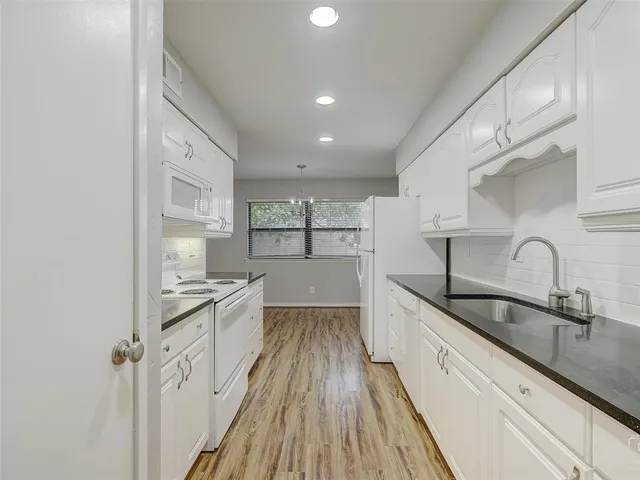 a large kitchen with a sink and cabinets