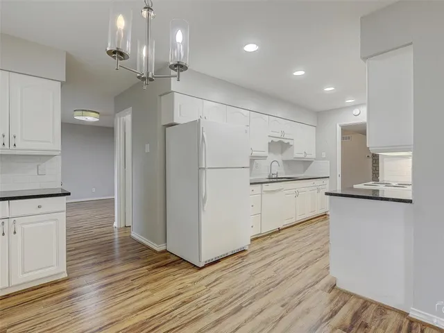 a kitchen with kitchen island white cabinets and stainless steel appliances