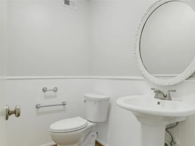 a bathroom with a sink a toilet and a mirror
