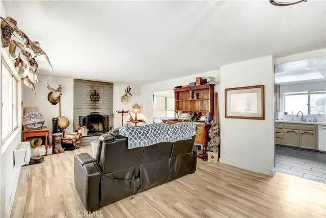 a living room with furniture a fireplace and kitchen view