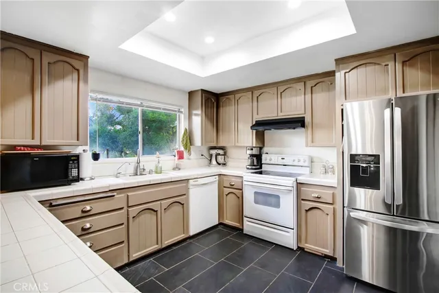 a kitchen with white cabinets and white appliances