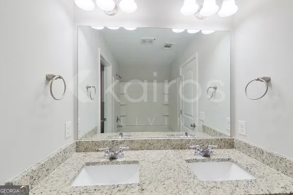 a bathroom with a sink vanity granite and a mirror