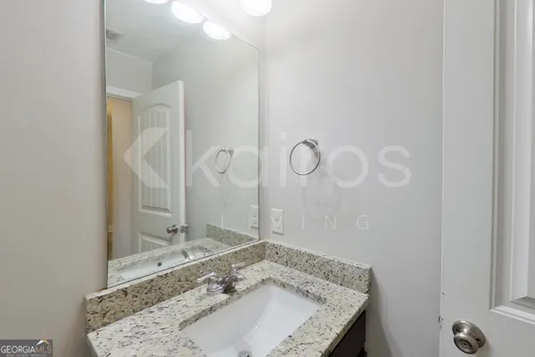 a bathroom with a granite countertop sink and a mirror