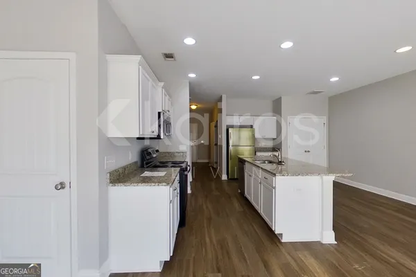 a kitchen with stainless steel appliances granite countertop a sink stove and refrigerator