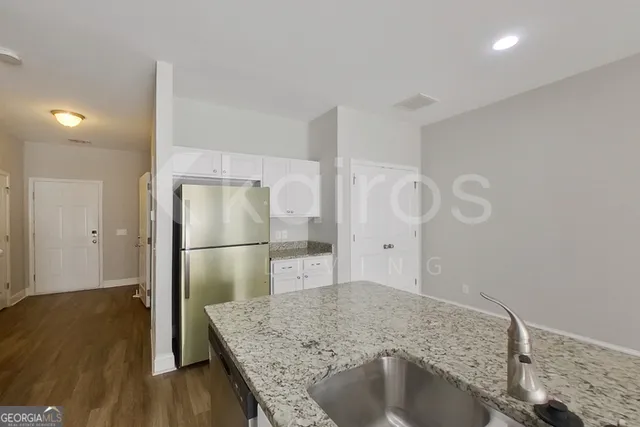a kitchen with kitchen island a refrigerator sink and stove