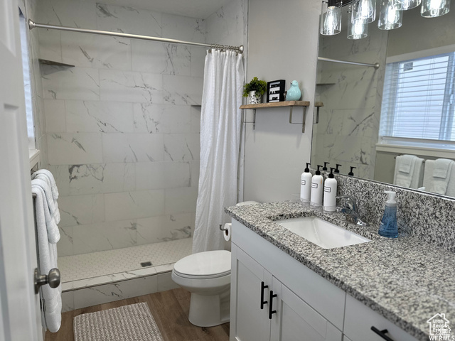 702 North 100 West Logan, UT 84321 - Photo 28 of 58 Bathroom with toilet, a tile shower, wood finished floors, and vanity