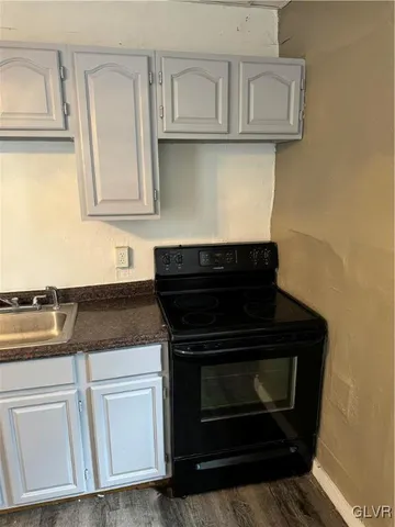 a kitchen with stainless steel appliances granite countertop a sink and a wooden floor