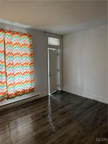 a view of an empty room and wooden floor