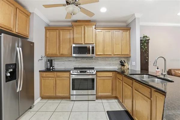 a kitchen with stainless steel appliances granite countertop a stove a sink dishwasher a refrigerator and a microwave oven