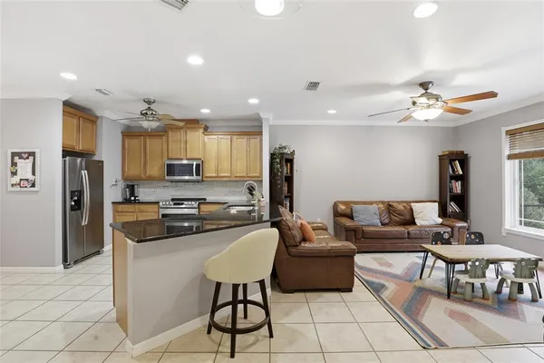 a living room with stainless steel appliances kitchen island granite countertop furniture and a view of kitchen
