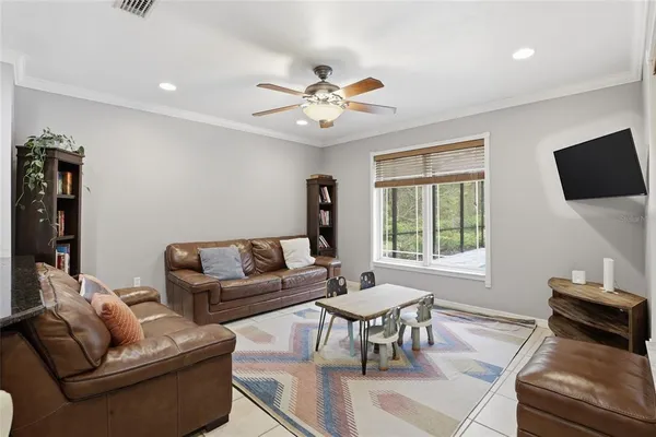 a living room with furniture a flat screen tv and a window